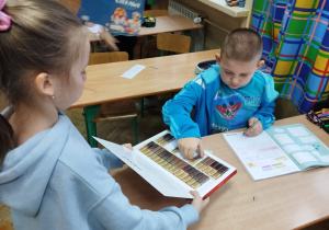 Uczennica częstuje kolegę czekoladą.