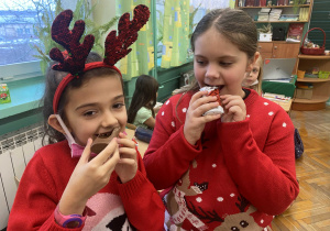 Dwie dziewczynki zajadają czekoladowe Mikołaje