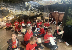 Uczniowie w czerwonych koszulkach podczas warsztatów w muzeum