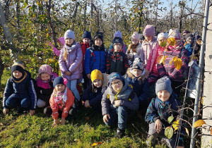 Zdjęcie uczniów na tle jabłoni w sadzie