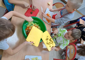 Dzieci kroją warzywa do sałatki