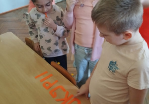 Uczniowie jedząc marchewki próbują ułożyć hasło z liter