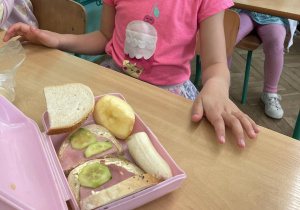 Zdjęcie przedstawia uczennice podczas drugiego śniadania, w śniadaniówce ma kolorowe owoce i warzywa