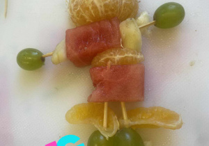 zdjęcie przedstawia ludzika wykonanego z kolorowych owoców i warzyw.
