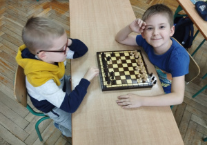 Chłopcy rozgrywają partię szachową.