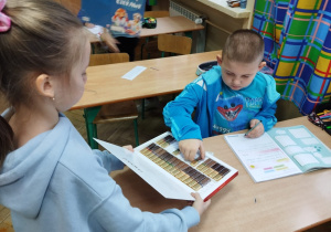 Uczennica częstuje kolegę czekoladą.