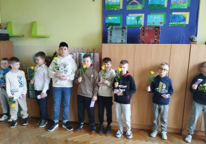 Chłopcy stoją z kwiatami