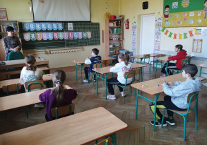 Uczniowie siedzą i czekają na dyktando