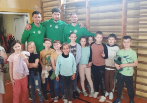 Uczniowie stoją razem z siatkarzami