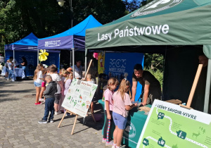 Uczniowie stoją przy stoiskach