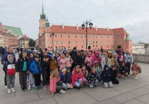 Uczniowie przy symbolu Warszawy