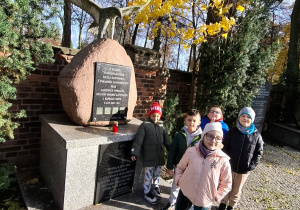 Uczniowie klasy pierwszej zapalają znicze