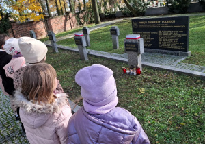 Uczniowie w zadumie przy pomniku pamięci