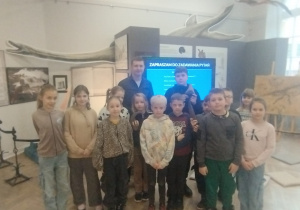 Uczniowie pozują do zdjęcia z paleontologim