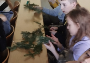 Uczniowie wąchają i oglądają dary lasu