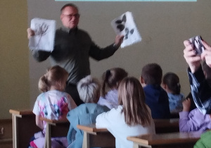 Wykładowca pokazuje karty z roślinami