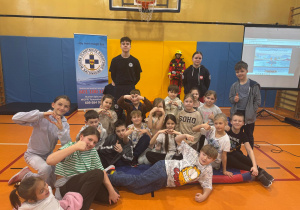 Uczniowie pozują do zdjęcia z ratownikami WOPR