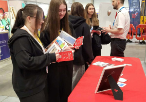 Uczennice przeglądają foldery reklamowe