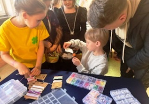 Dzieci tworzą bransoletki z symboliczną zieloną koniczyną