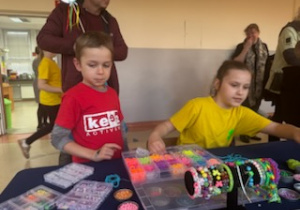 Dzieci tworzą bransoletki z symboliczną zieloną koniczyną