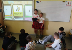 Uczennice czytają informacje o Dniu Kolorowej Skarpetki