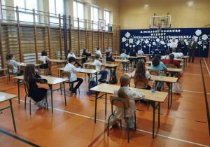 Uczniowie siedzą w ławkach