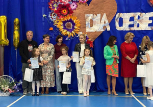 Uczniowie z opiekunami odbierający nagrody